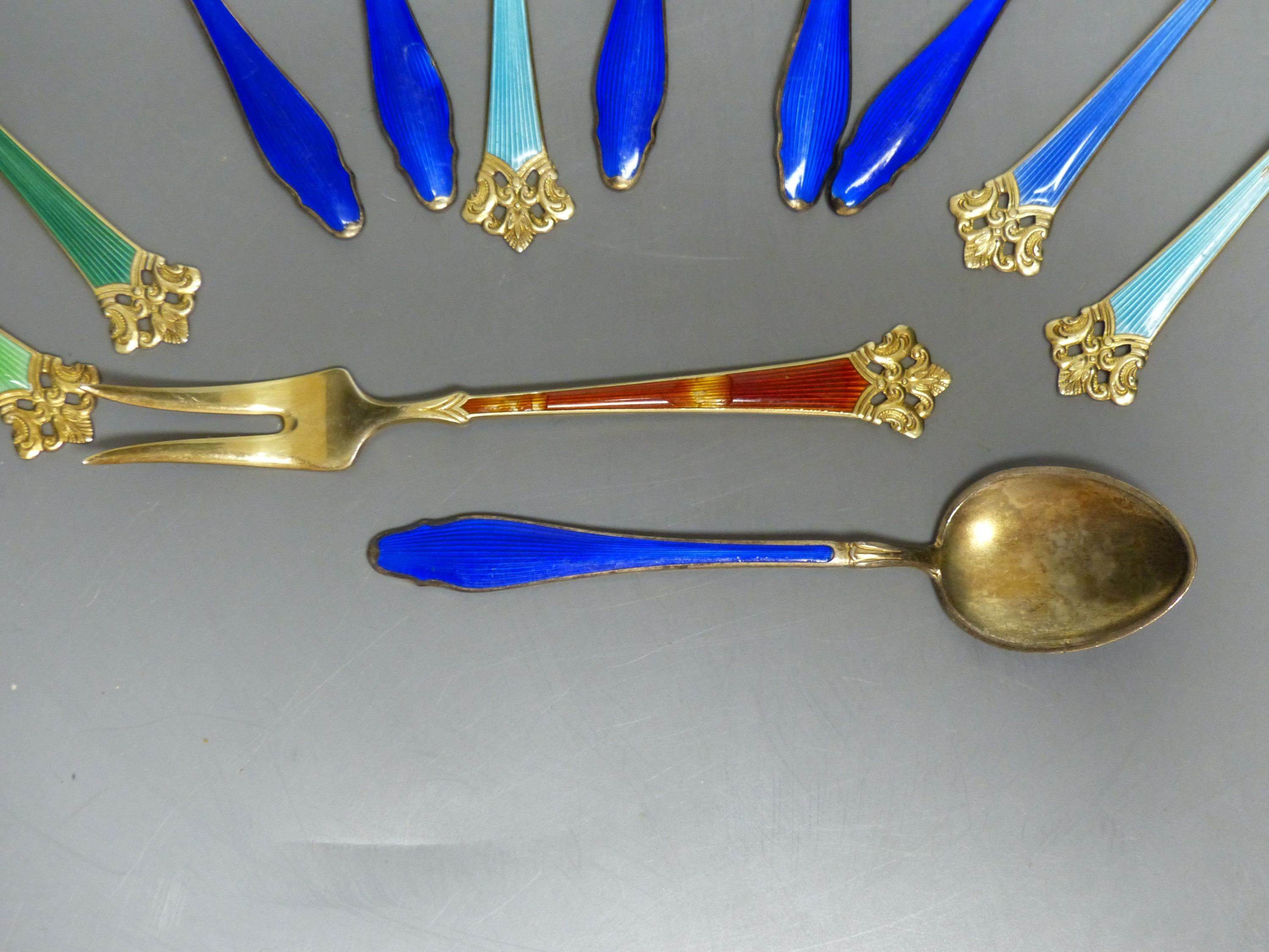 Six Norwegian sterling gilt and enamel small forks and six sterling and blue enamel coffee spoons.